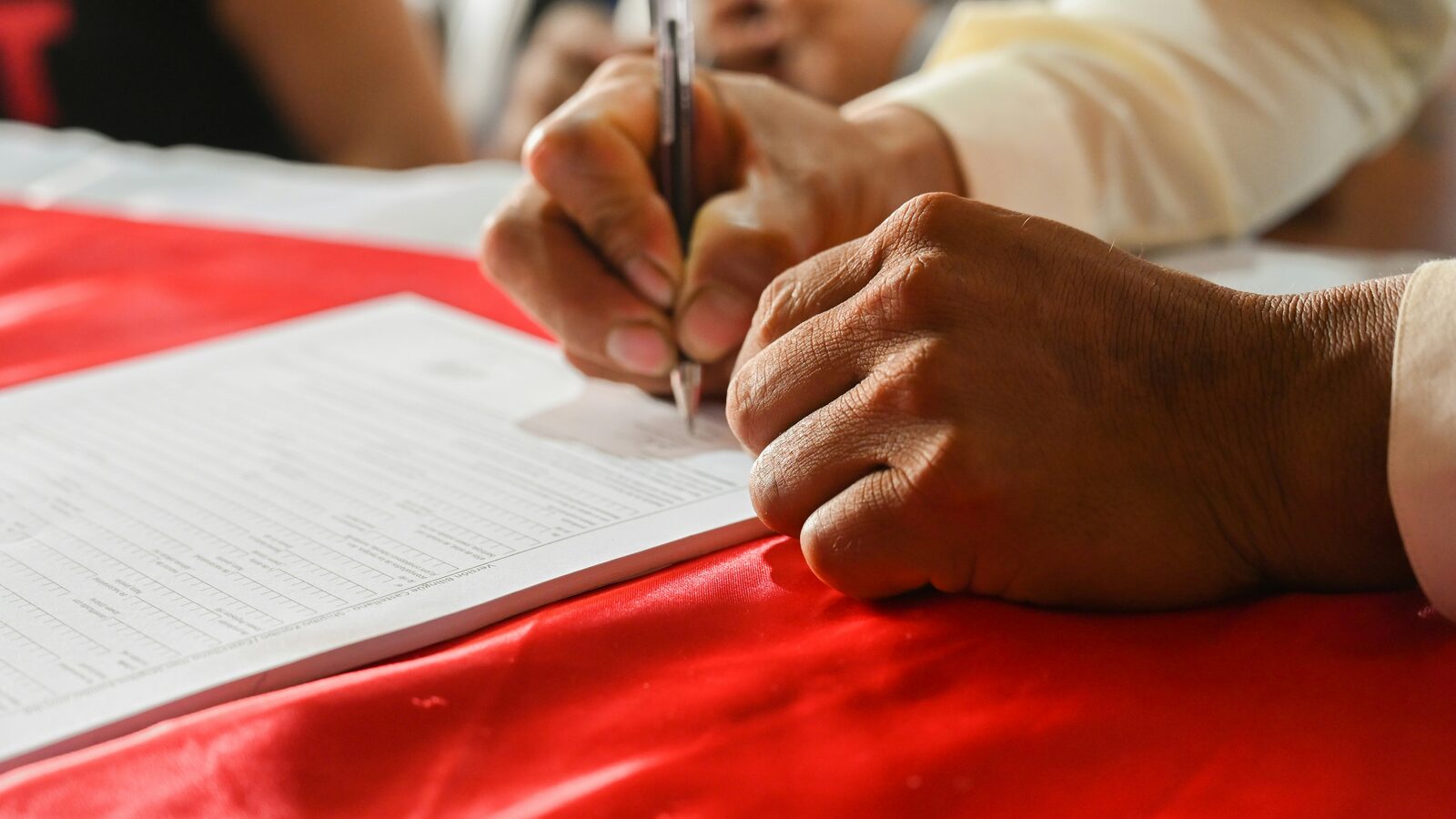 Hand beim Unterzeichnen einer Petition als Symbol für politische Bürgerbeteiligung